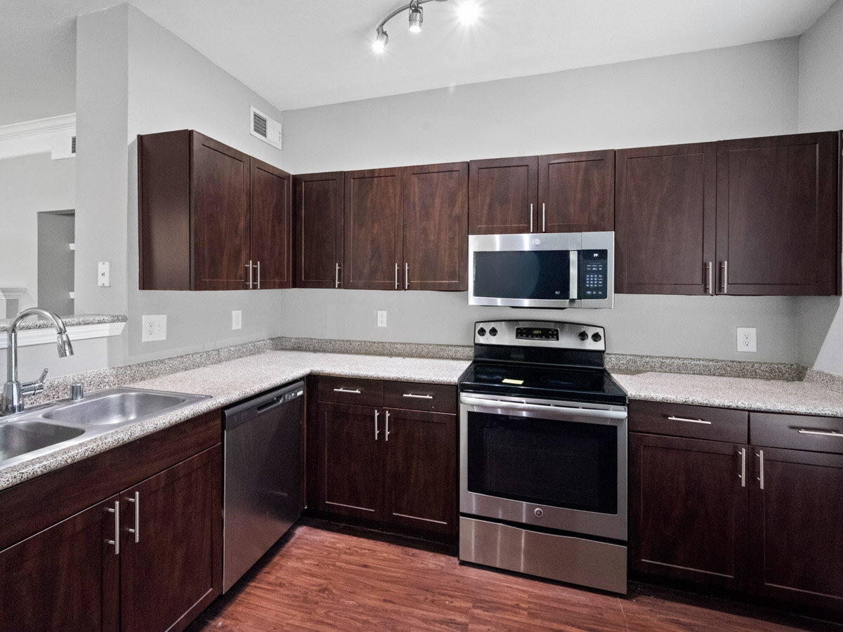Kitchen with dark wood cabinets, granite countertops, and stainless steel appliances